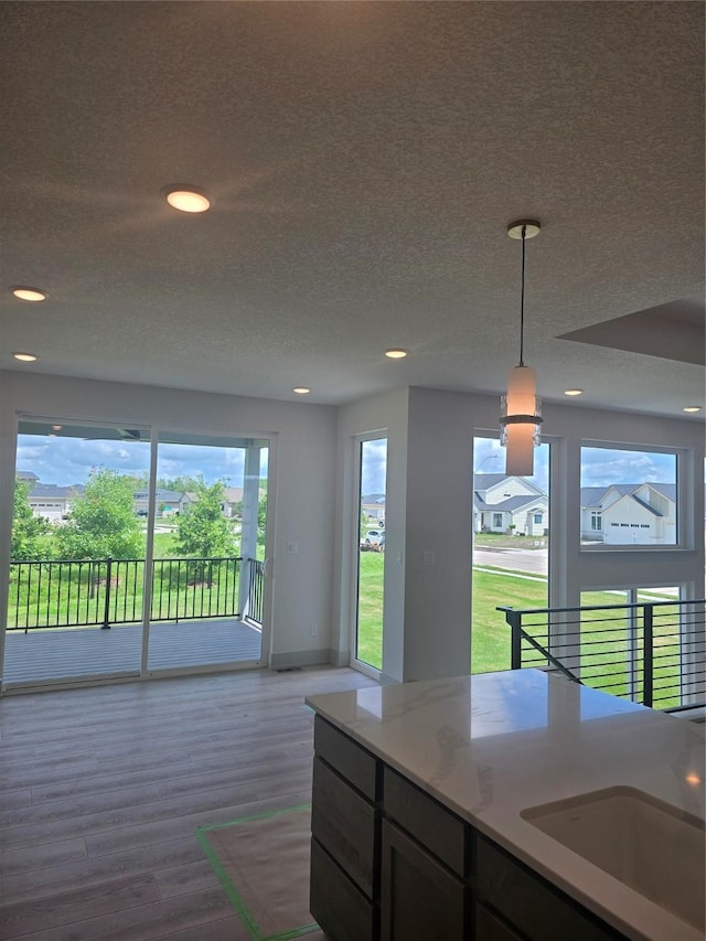 16203 Goodman Dr, Urbandale, IA 50323 - kitchen featuring wood finished floors, pendant lighting, recessed lighting, and a textured ceiling