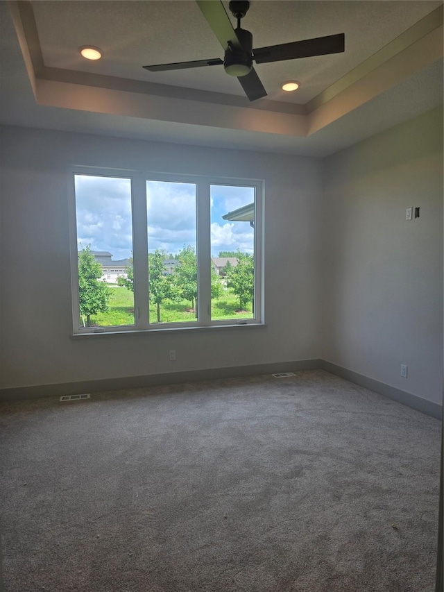 16203 Goodman Dr, Urbandale, IA 50323 - empty room featuring a raised ceiling, carpet, ceiling fan, and recessed lighting