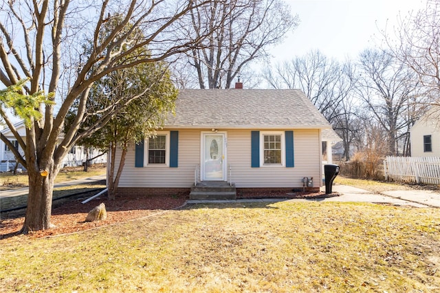 bungalow featuring a shingled roof, fence, entry steps, a front yard, and a chimney