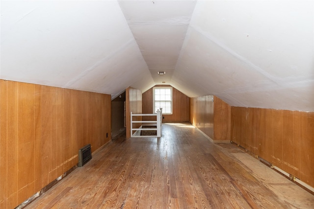 bonus room featuring visible vents, wood finished floors, lofted ceiling, and wood walls