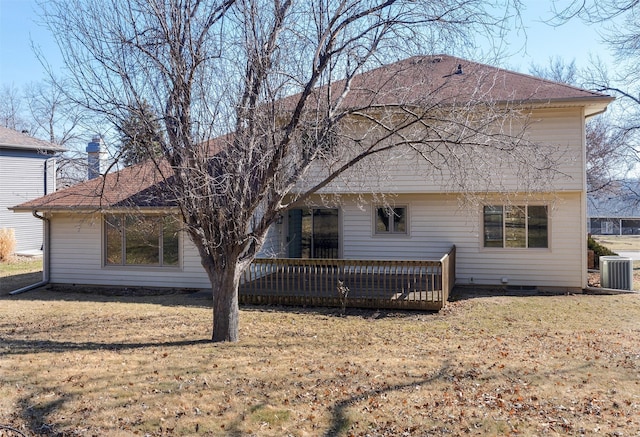 rear view of property with a yard, a wooden deck, and central AC