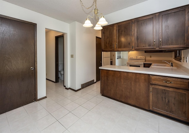 kitchen with a sink, light countertops, a chandelier, and white electric stove