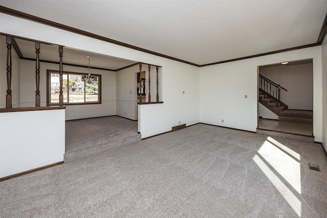 unfurnished living room with stairs, ornamental molding, carpet, and a textured ceiling