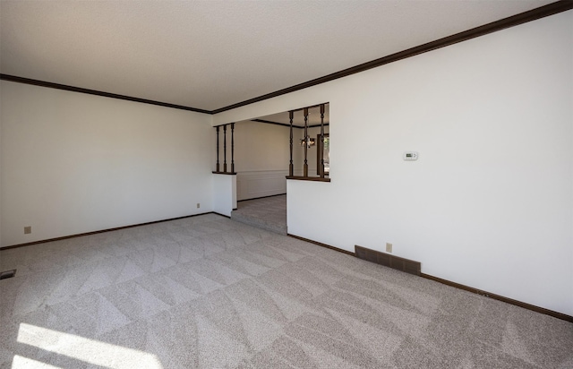 carpeted spare room with visible vents, baseboards, and ornamental molding