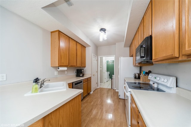 kitchen featuring a sink, black microwave, stainless steel dishwasher, white electric range, and washer and clothes dryer