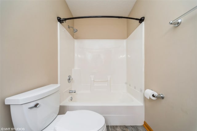 bathroom featuring tub / shower combination and toilet