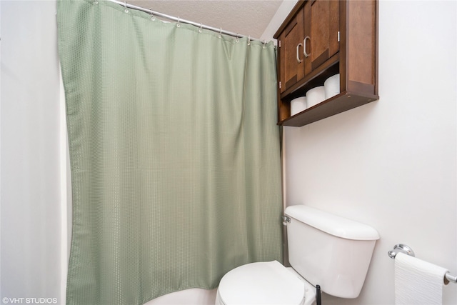 bathroom featuring curtained shower and toilet