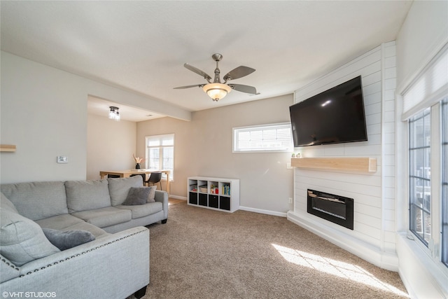 carpeted living room featuring a fireplace, baseboards, and ceiling fan