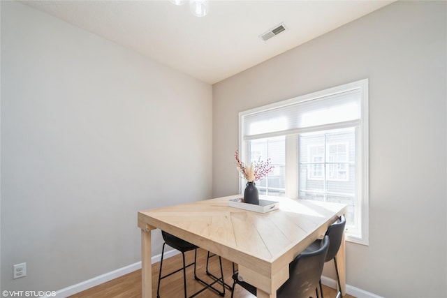 dining area with visible vents, baseboards, and light wood finished floors