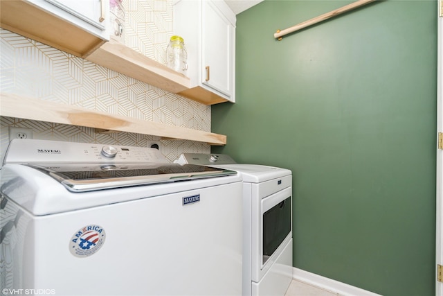 laundry room featuring baseboards, cabinet space, and separate washer and dryer