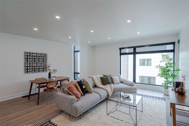 living room with recessed lighting, baseboards, and wood finished floors