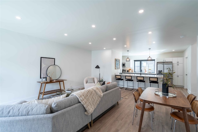 living room featuring recessed lighting, light wood-style floors, and baseboards