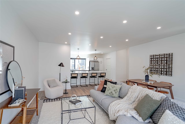 living room featuring recessed lighting, baseboards, and light wood-style floors