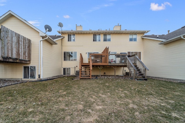 rear view of property featuring stairway, a lawn, a chimney, and a deck