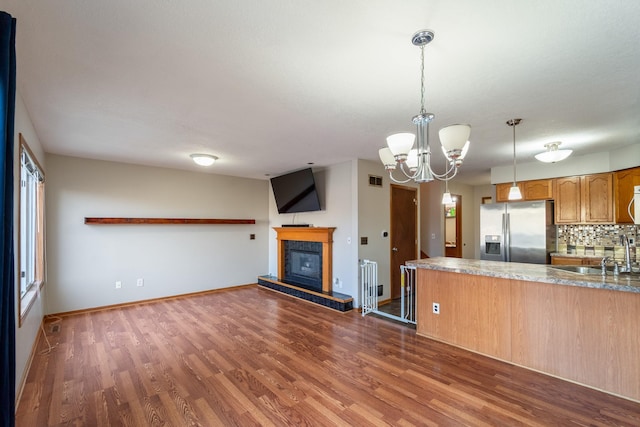 1013 10th Ave NW, Altoona, IA 50009 - kitchen with stainless steel fridge, dark wood finished floors, decorative backsplash, a chandelier, and a sink
