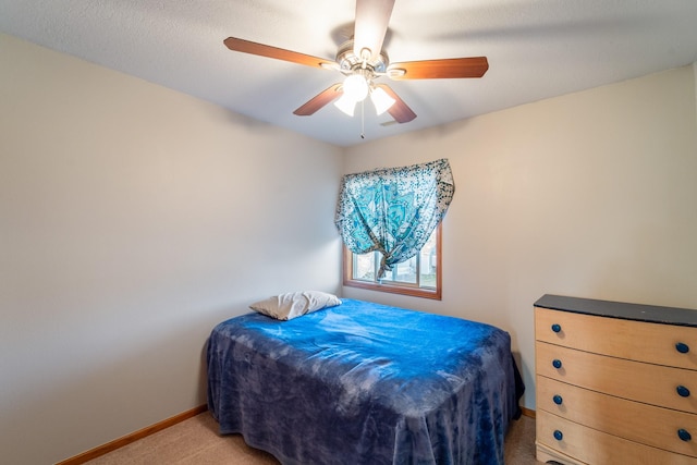 bedroom with a ceiling fan, light colored carpet, and baseboards