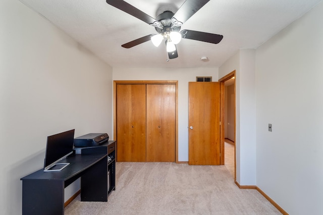 office area with a ceiling fan, light colored carpet, and baseboards