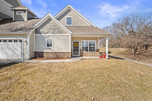 view of front of property featuring a front yard, a garage, stone siding, and a shingled roof