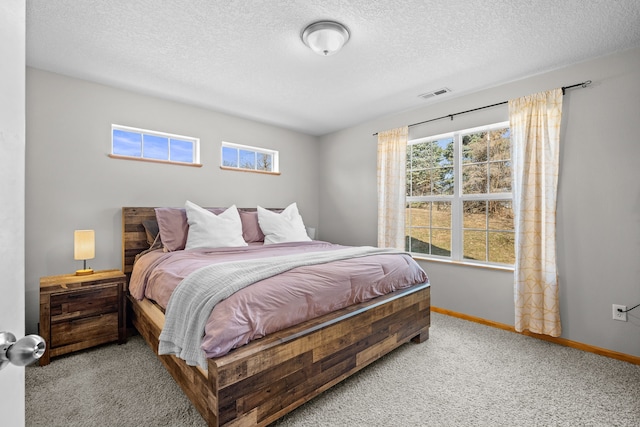 bedroom featuring visible vents, baseboards, carpet, and a textured ceiling