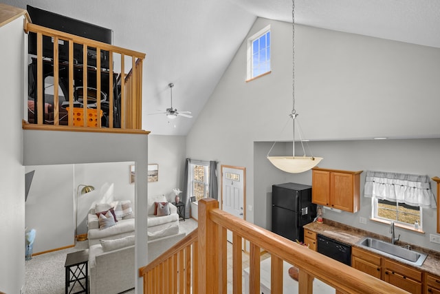 kitchen with high vaulted ceiling, black appliances, a ceiling fan, a sink, and carpet floors