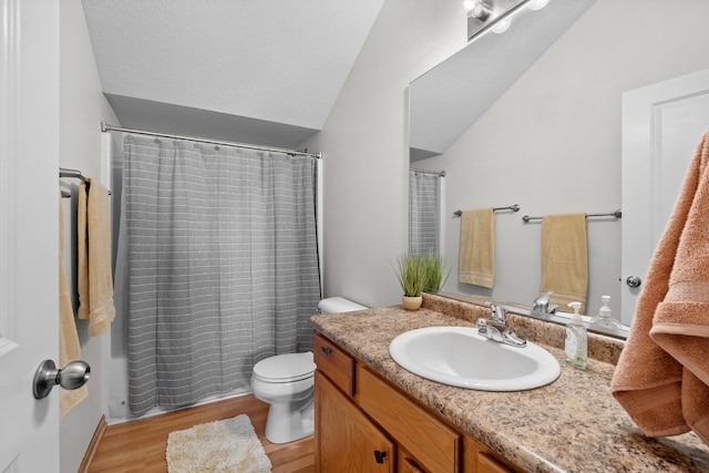 bathroom featuring toilet, a shower with shower curtain, lofted ceiling, wood finished floors, and vanity