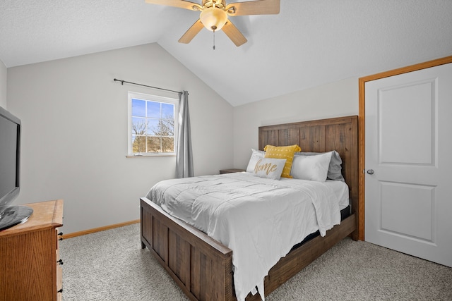 bedroom featuring a ceiling fan, baseboards, lofted ceiling, a textured ceiling, and light carpet