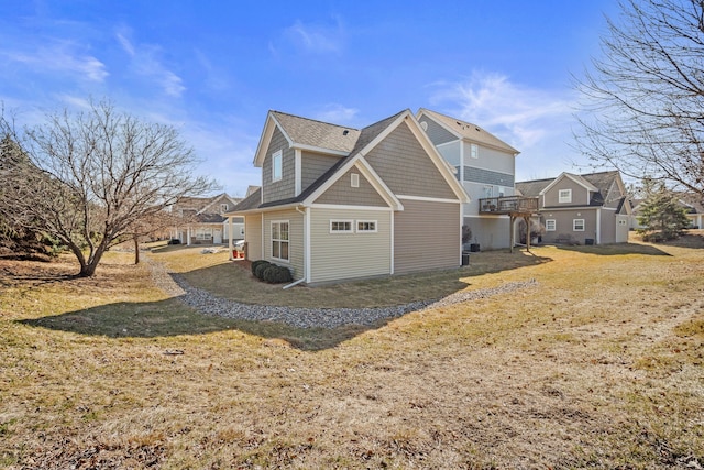 view of property exterior featuring a shingled roof and a yard