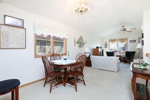 dining area featuring ceiling fan with notable chandelier, vaulted ceiling, carpet, and baseboards