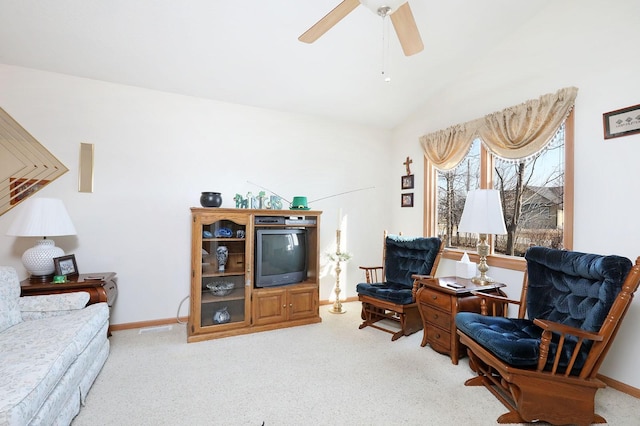 sitting room with baseboards, light carpet, ceiling fan, and vaulted ceiling