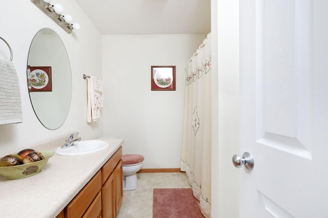 bathroom featuring baseboards, toilet, and vanity