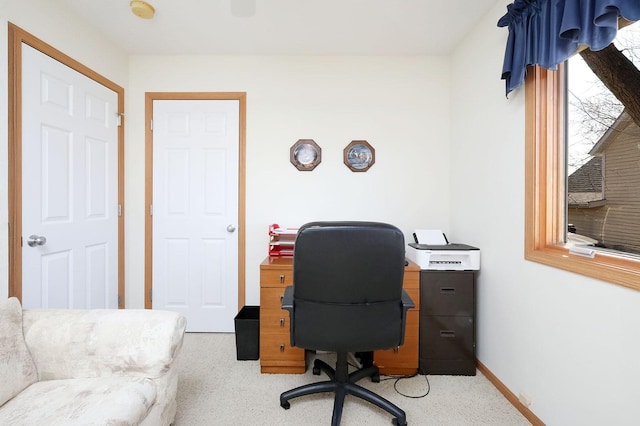 carpeted office space featuring baseboards