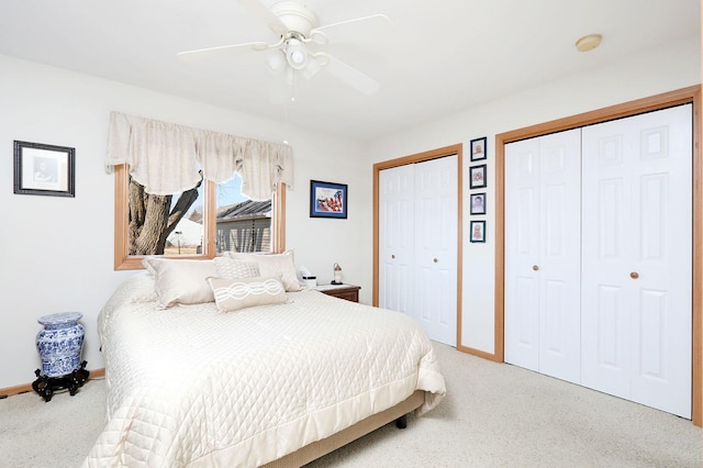 bedroom featuring baseboards, carpet, and multiple closets