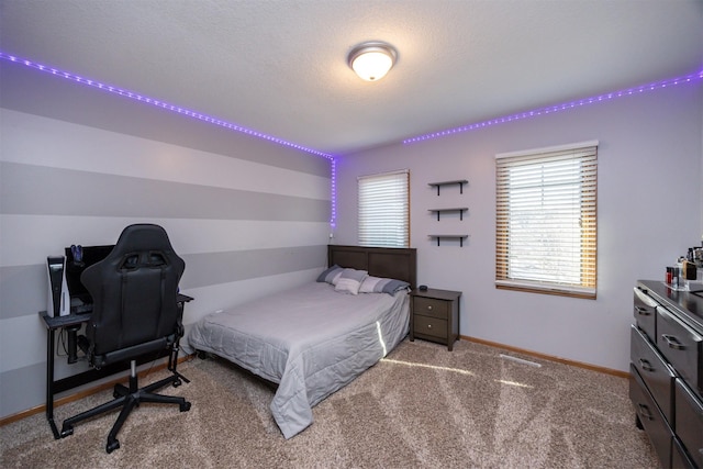 bedroom featuring carpet, baseboards, and a textured ceiling