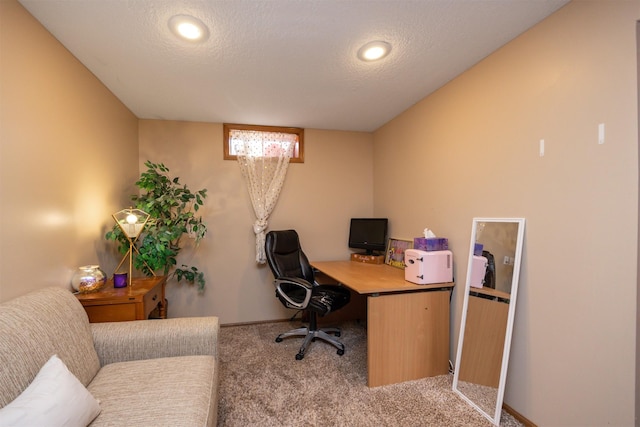 carpeted office with baseboards and a textured ceiling