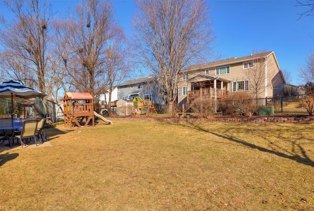 view of yard with a playground, a trampoline, and fence