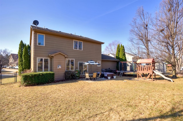 rear view of property with a playground, a trampoline, fence, a lawn, and a patio