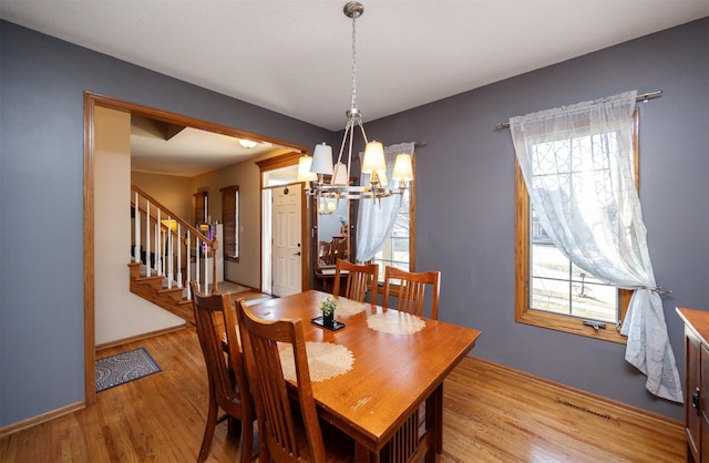 dining area featuring a notable chandelier, plenty of natural light, light wood-style flooring, and visible vents