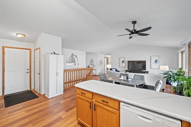 kitchen featuring a ceiling fan, lofted ceiling, light countertops, dishwasher, and light wood-type flooring