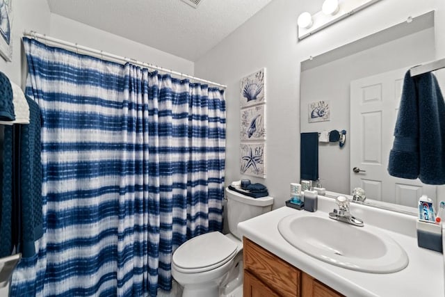 bathroom with vanity, a shower with shower curtain, toilet, and a textured ceiling