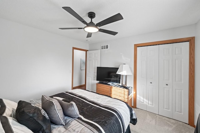 bedroom with light carpet, visible vents, ceiling fan, and a closet