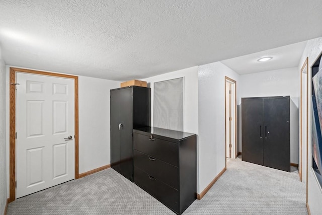 carpeted bedroom with a textured ceiling and baseboards