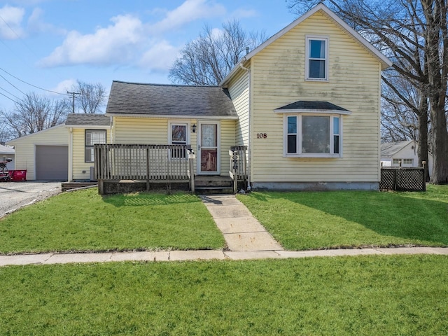 traditional-style home with a front lawn, a garage, an outdoor structure, and a shingled roof