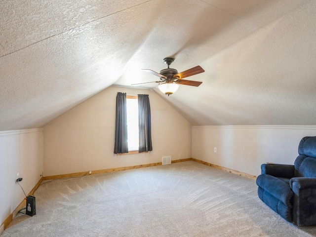 additional living space featuring visible vents, a ceiling fan, carpet, and vaulted ceiling