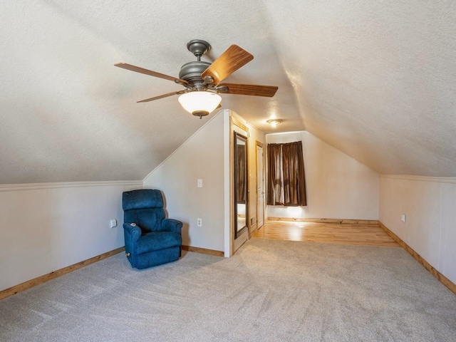 additional living space featuring ceiling fan, a textured ceiling, lofted ceiling, and carpet