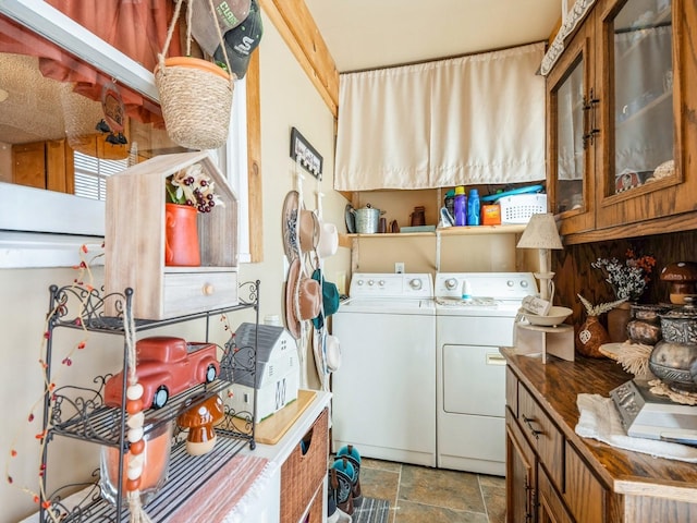 clothes washing area featuring washer and dryer and stone finish flooring