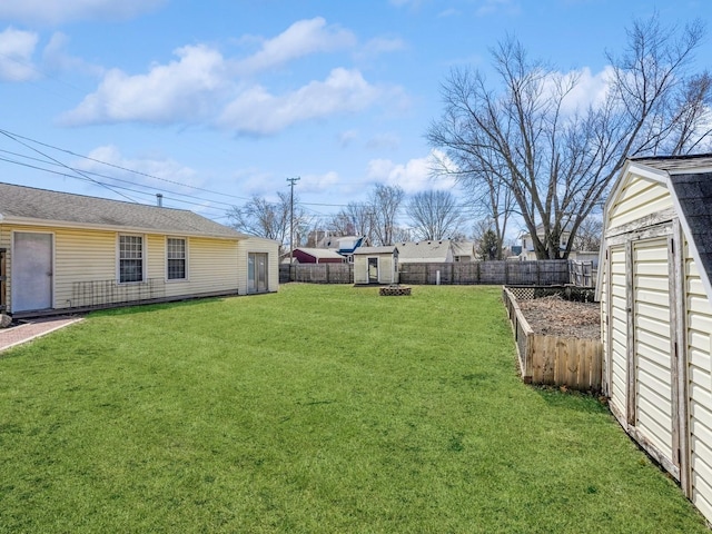 view of yard with an outbuilding, a fenced backyard, and a storage shed