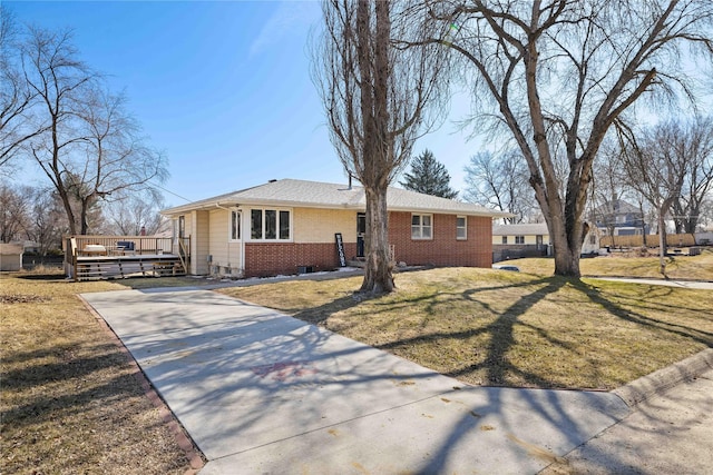 ranch-style house featuring a front yard, concrete driveway, and brick siding