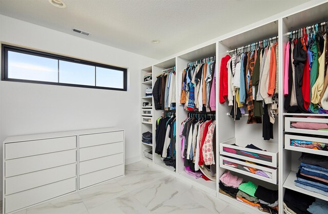 walk in closet with visible vents and marble finish floor