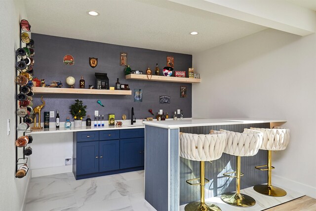 bar featuring recessed lighting, baseboards, wet bar, and marble finish floor