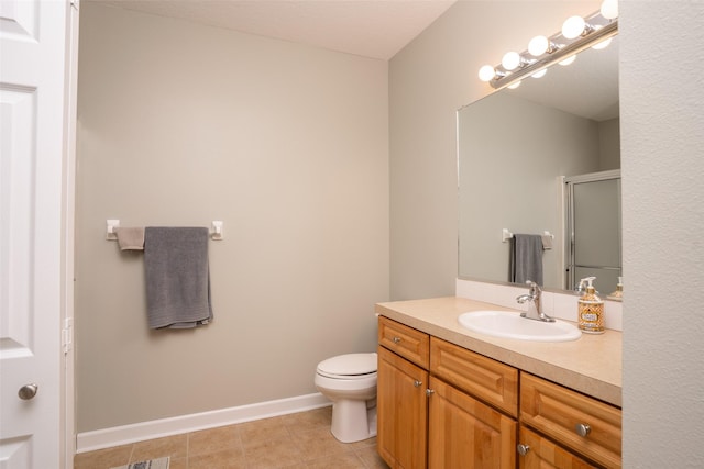 bathroom with toilet, a stall shower, tile patterned flooring, baseboards, and vanity